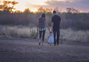 parents walk with toddler